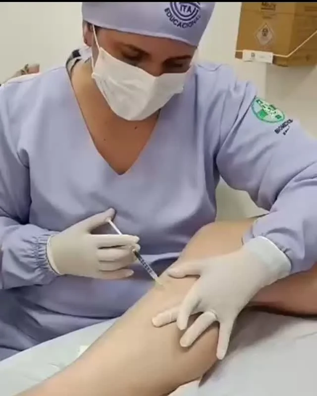 A Dra. Polianna aplicando escleroterapia na perna de uma paciente